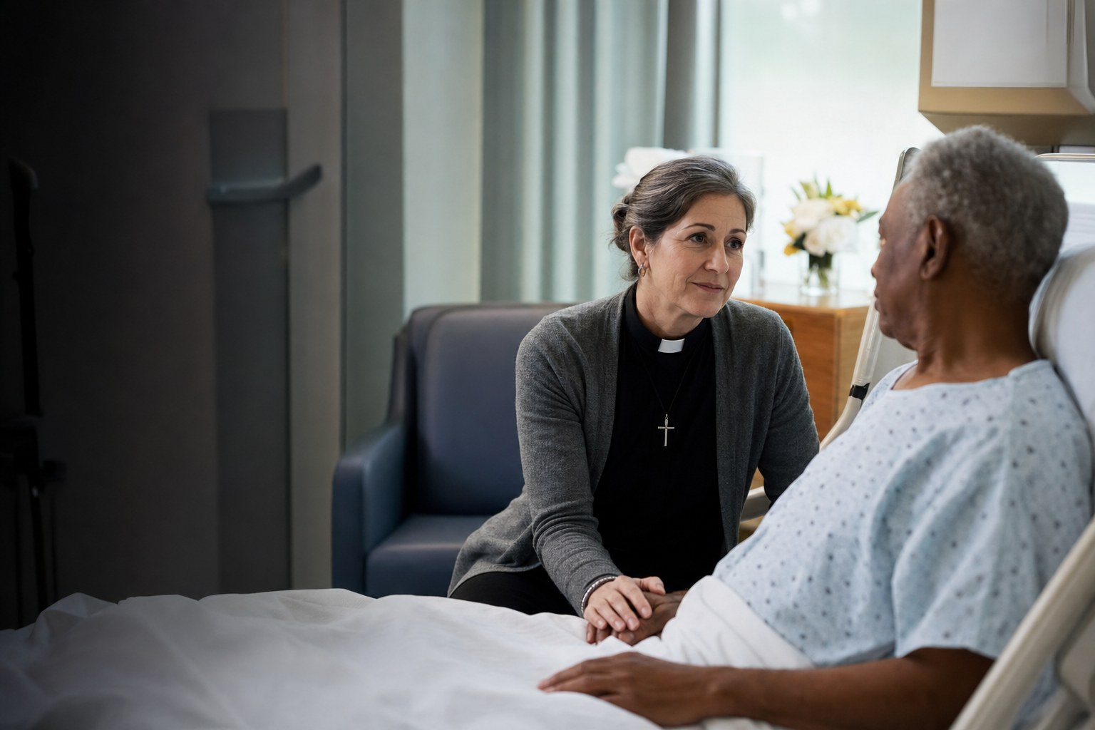 Pastor Joanna visiting an older neighbor at a hospital bedside